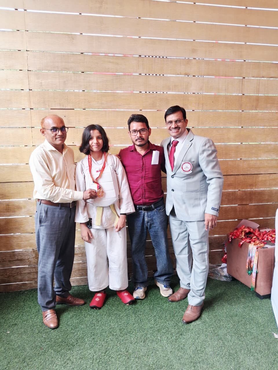 Young Karate student receiving a medal from officials at a tournament, trained at Sports Zone LLP, Patna