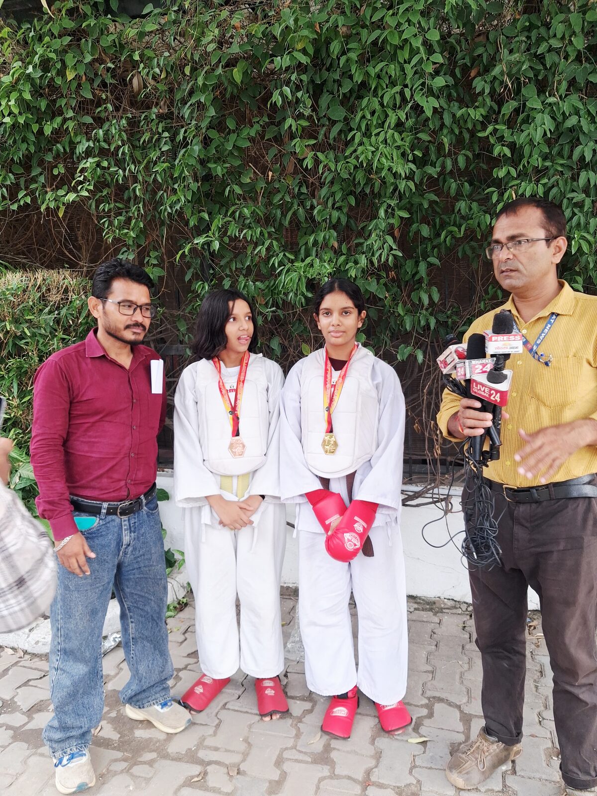 News channel reporter interviewing Sports Zone LLP Karate medallists on camera