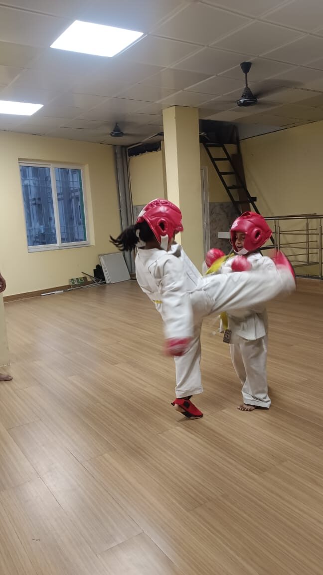 Young Karate students practicing a kicking technique during sparring at Sports Zone LLP, Patna