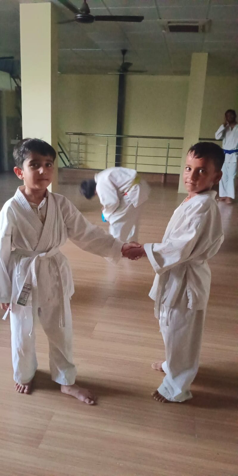 Young Karate students shaking hands as a mark of sportsmanship at Sports Zone LLP, Patna